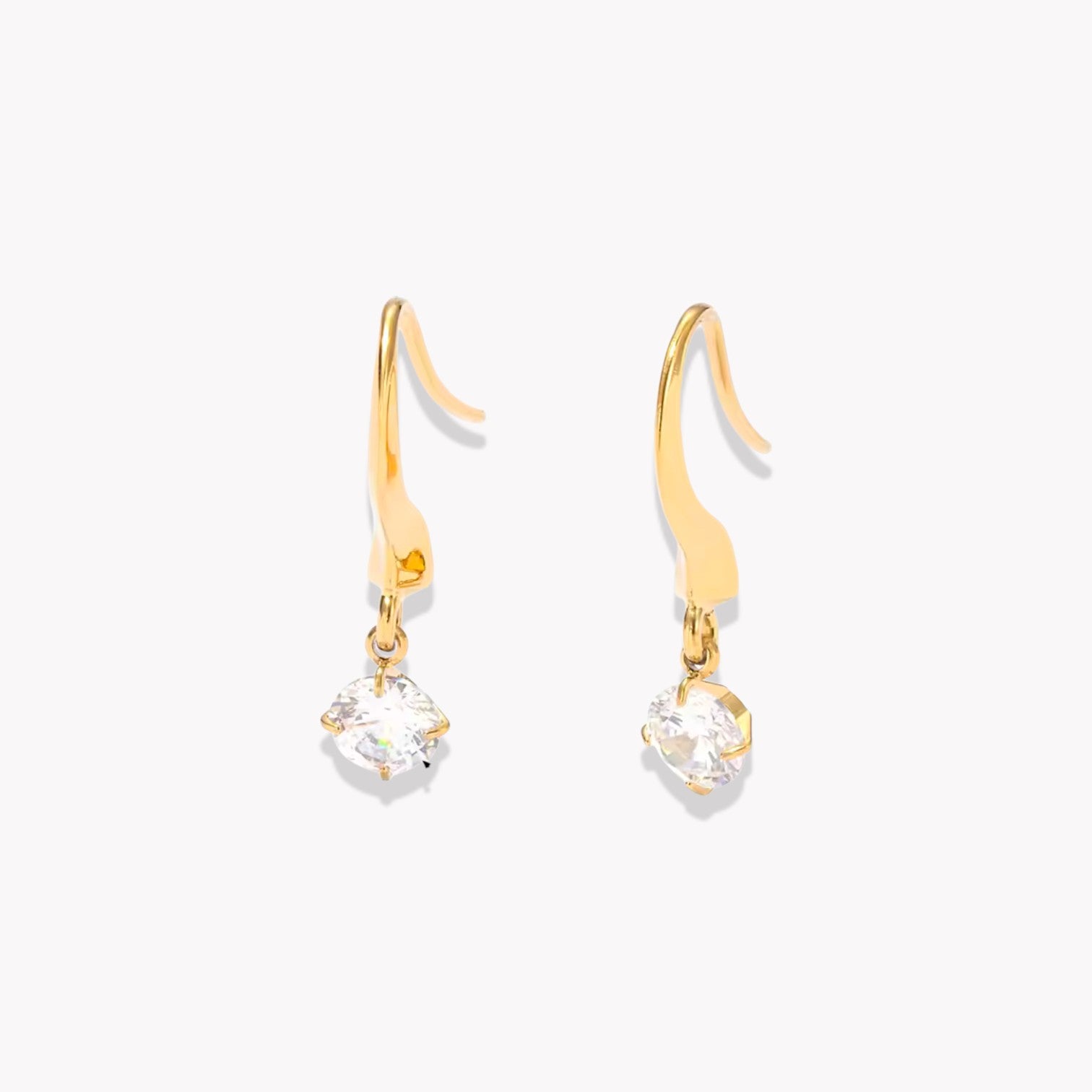 Gold earrings with clear gemstones on a white background