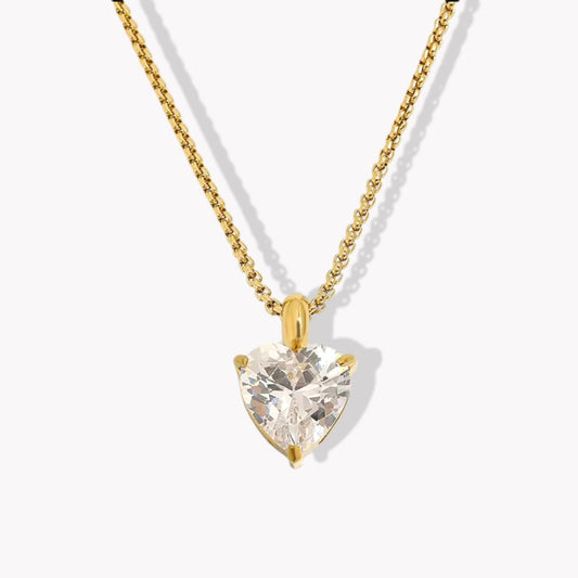 Gold Heart-shaped diamond pendant on a chain against a white background