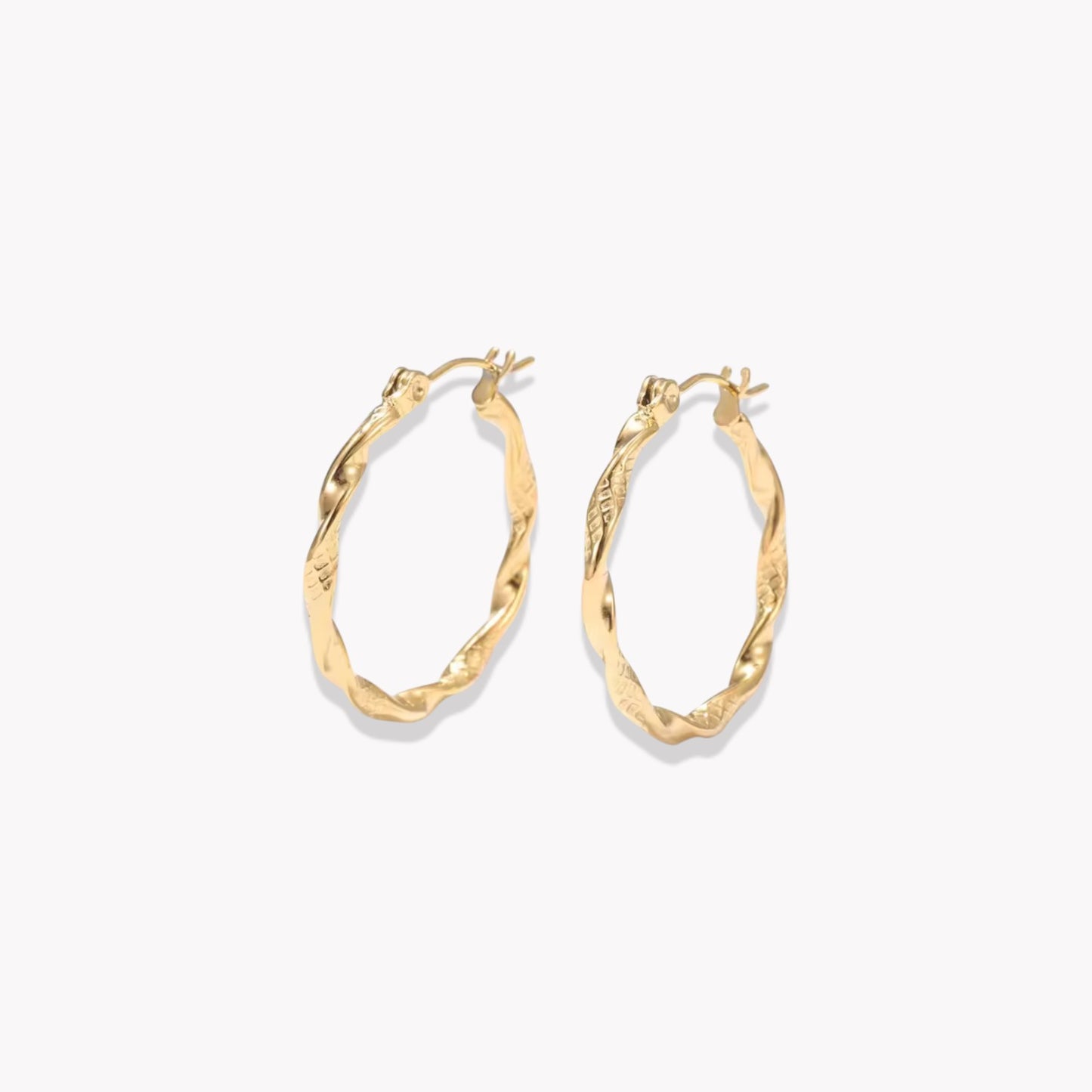 Gold twist hoop earrings on a white background