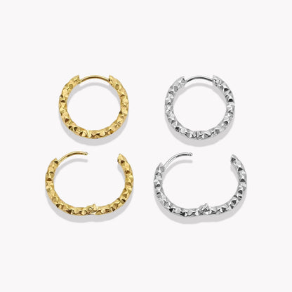 Gold and silver hooped earrings being shown in an open and closed position, pictured on a white background