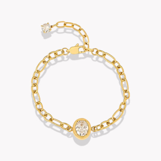 Gold chain bracelet with large central oval diamond. Bracelet has an extender with a clear gemstone on the end. Pictured on a white background