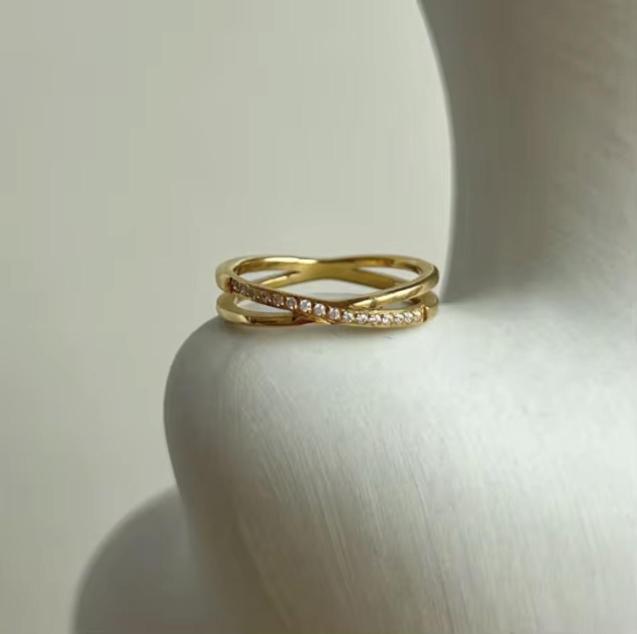 Gold ring with diamond accents on a white surface