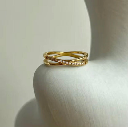 Gold ring with diamond accents on a white surface