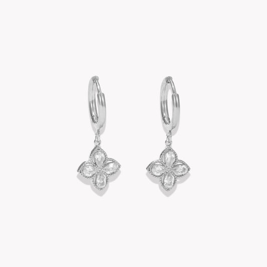 Silver earrings with clear gemstone detail pictured on a light grey background