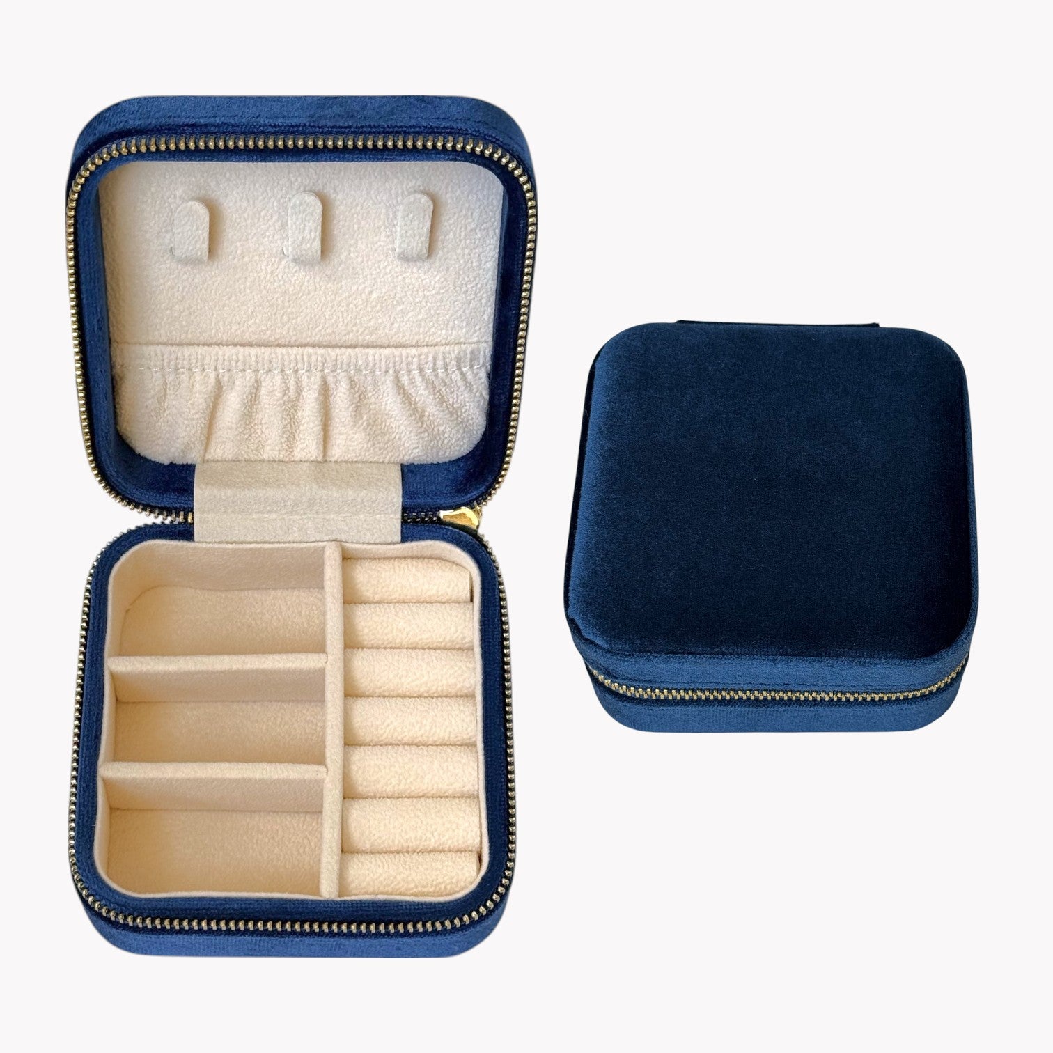 Navy blue jewelry case with beige interior compartments on a white background