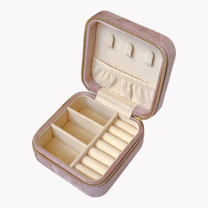 Pink jewelry box with compartments for earrings and rings on a white background