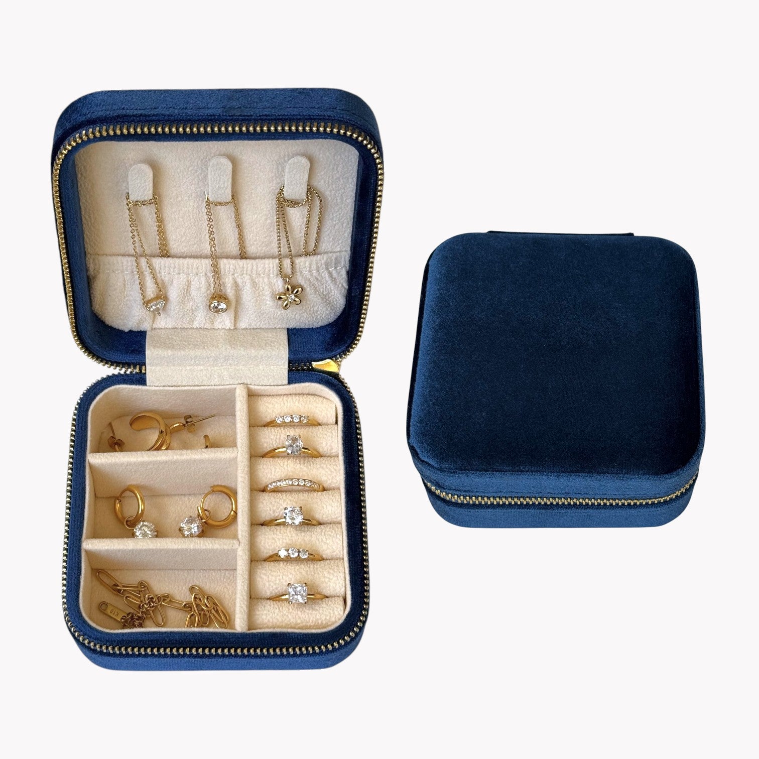 Blue jewelry case with gold and silver jewelry inside on a white background