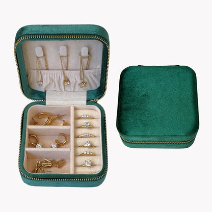 Green jewelry case with compartments for earrings, rings, and necklaces on a white background