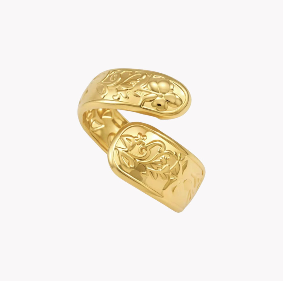 A gold-colored open cuff ring with detailed floral engravings, shown on a plain white background.