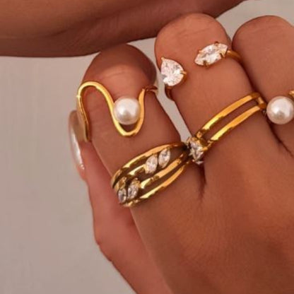 Gold ring with layers of ring band and four marquise shaped stones being worn on a finger - with other rings