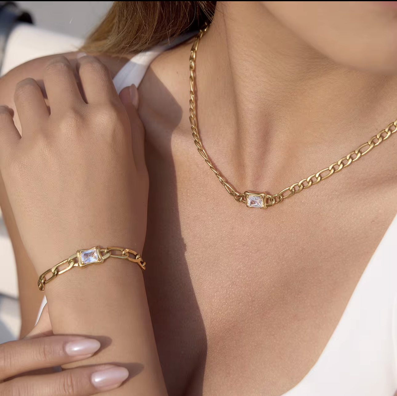 Gold chain necklace and bracelet on a person's wrist and neck