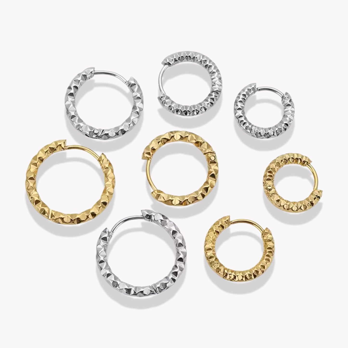 4 pairs of gold hooped earrings in different sizes, pictured on a white background