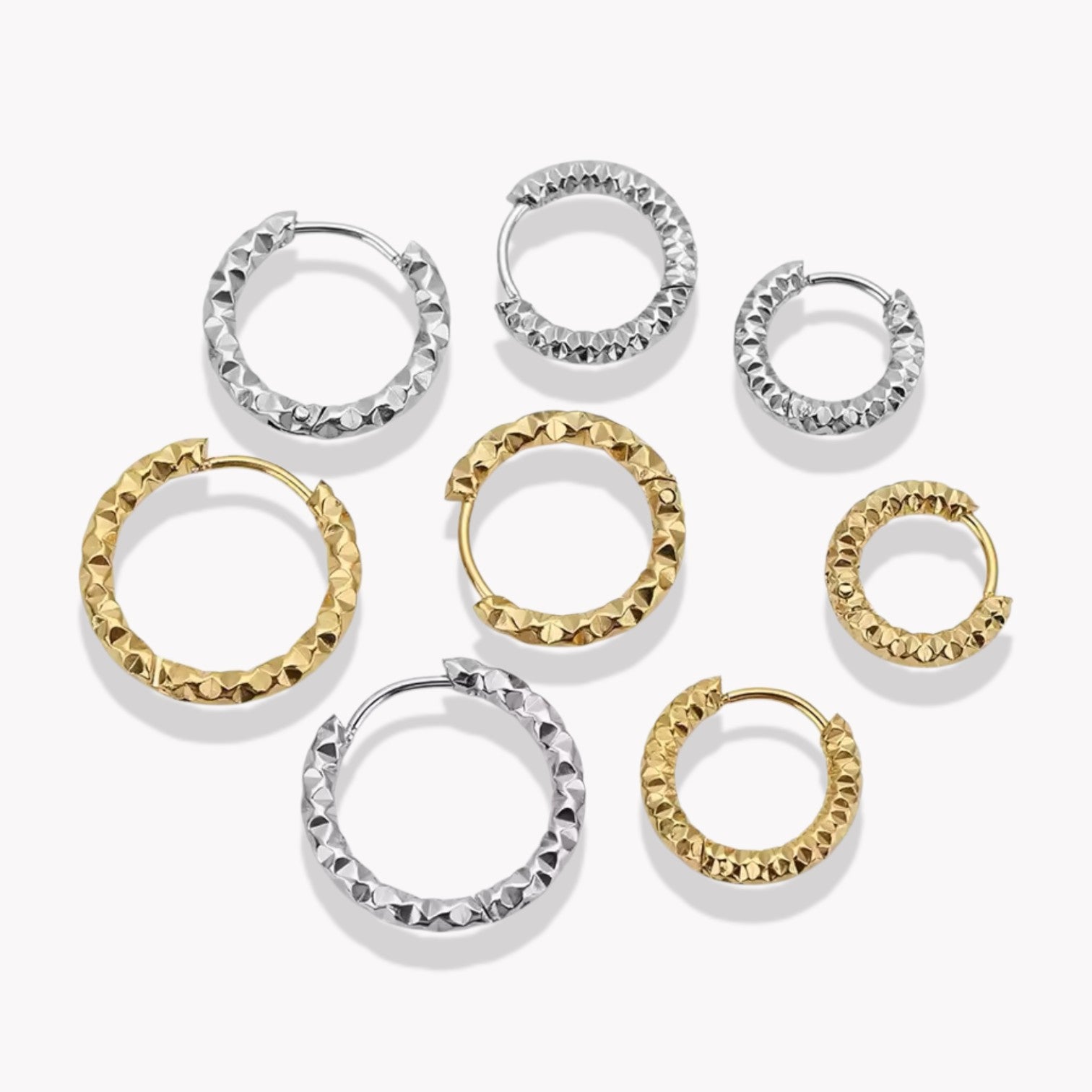 4 pairs of gold hooped earrings in different sizes, pictured on a white background