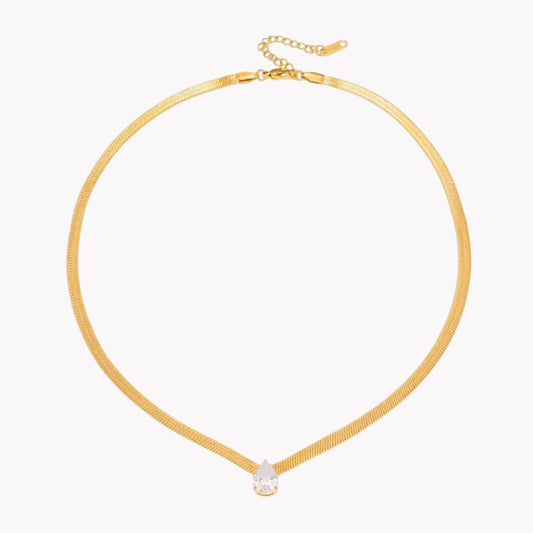 Gold necklace with a small pear pendant on a white background