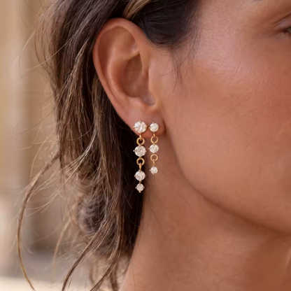 gold earrings with round gemstones pictured being worn