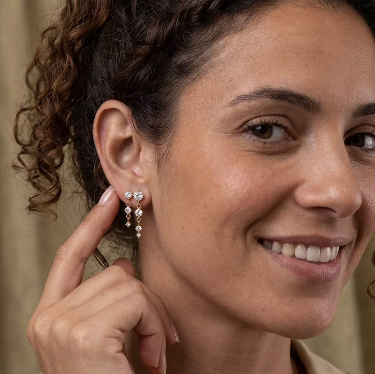 gold earrings with round gemstones pictured being worn