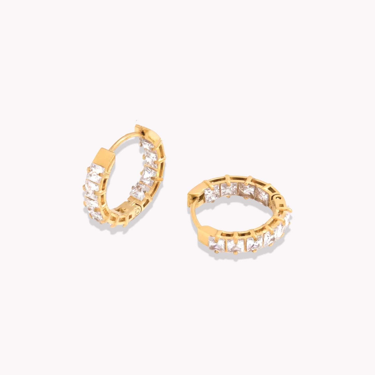 Gold hoops featuring gemstone detail pictured on a light grey background