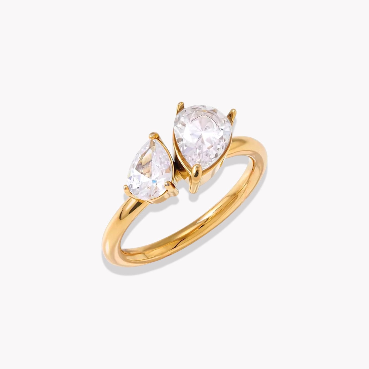 Gold ring with two pear-shaped diamonds on a white background