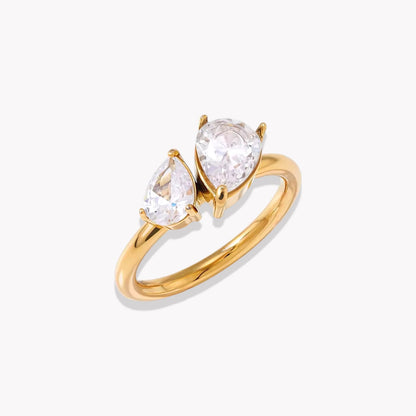 Gold ring with two pear-shaped diamonds on a white background