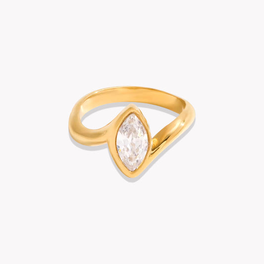 Gold ring with a marquise shaped stone pictured on a white background