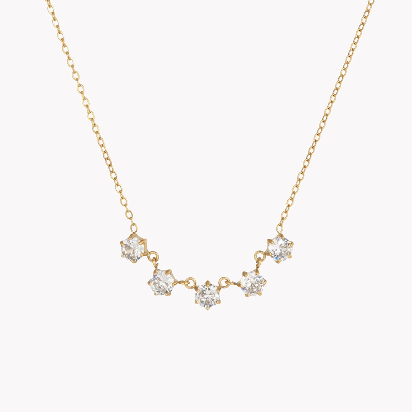 Gold necklace with diamond-like stones on a white background