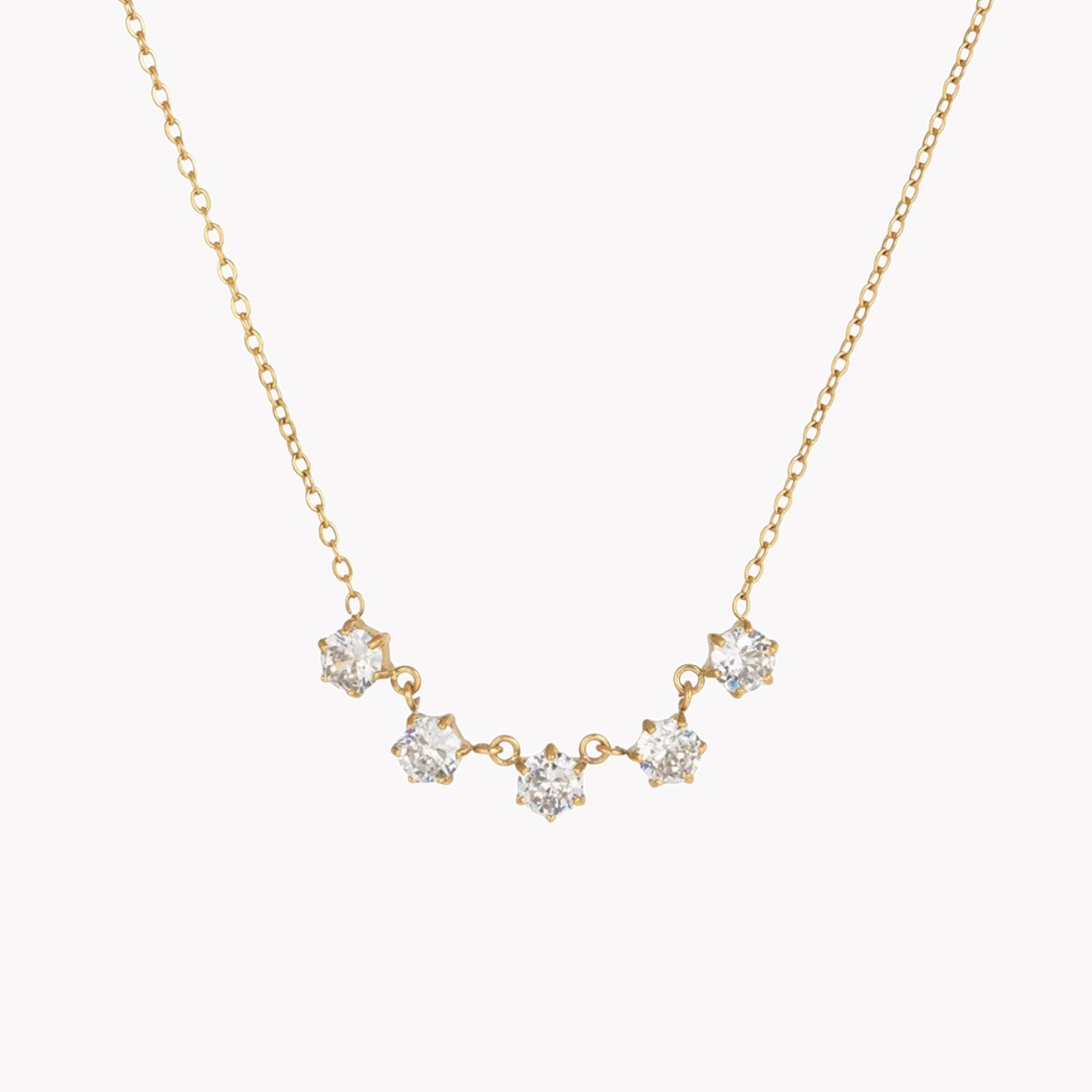Gold necklace with diamond-like stones on a white background