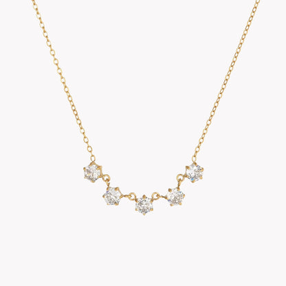 Gold necklace with diamond-like stones on a white background