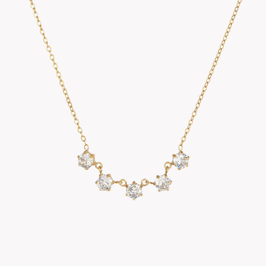 Gold necklace with diamond-like stones on a white background