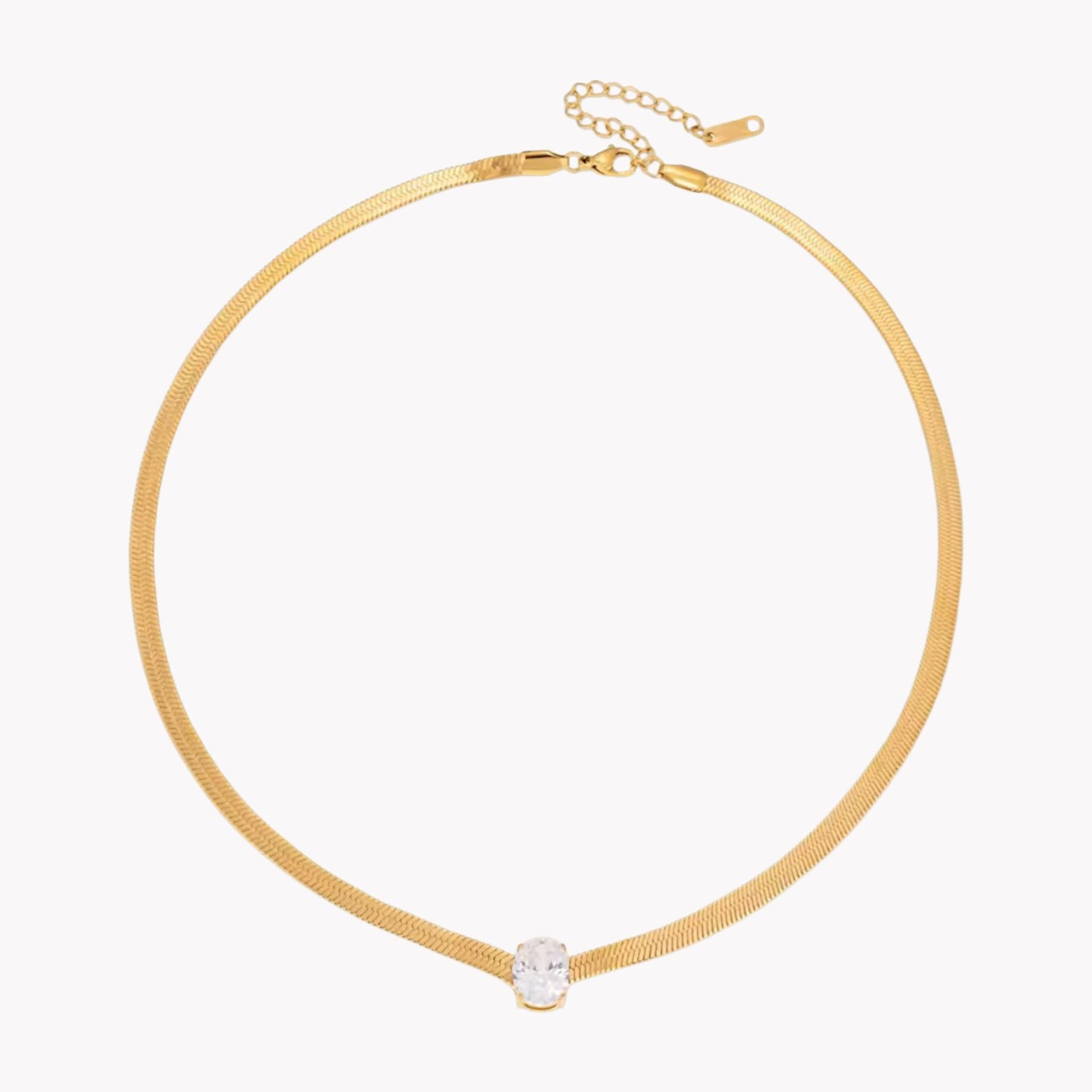 gold necklace with oval gemstone pictured on a white background