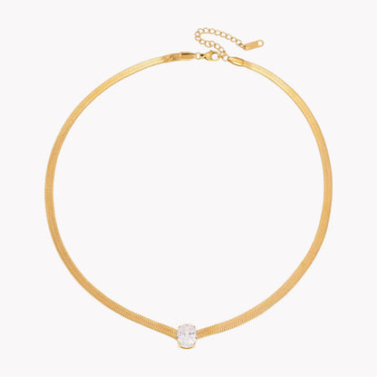 gold necklace with oval gemstone pictured on a white background