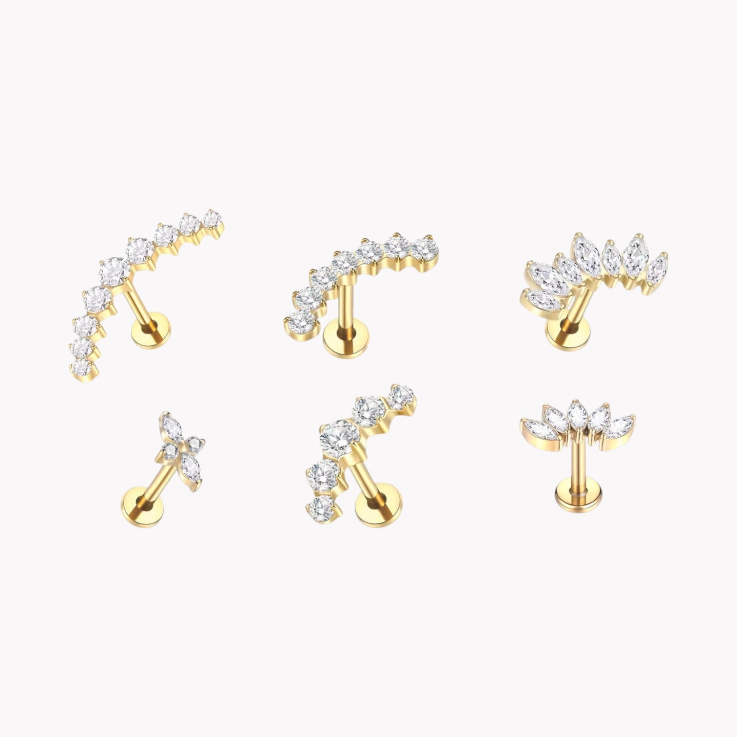 Set of gold earrings with clear gemstones on a white background
