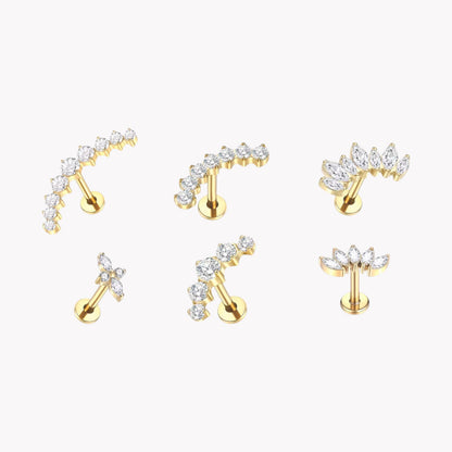 Set of gold earrings with clear gemstones on a white background