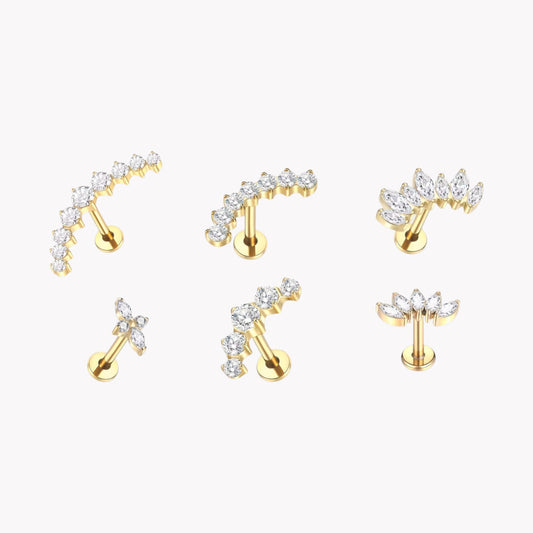 Set of gold earrings with clear gemstones on a white background