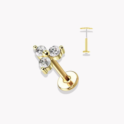 Set of gold earrings with clear gemstones on a white background