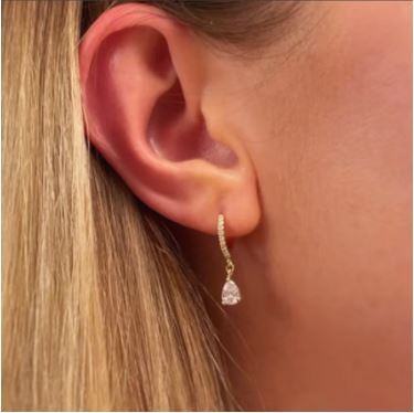 Silver hoop earrings with diamonds on the hoop and a pear shaped drop pendant being worn in an ear