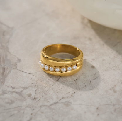 Gold ring with pearls on a marble surface