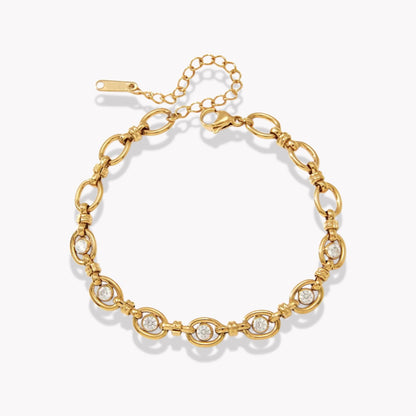 gold bracelet with genstones pictured on a light grey background