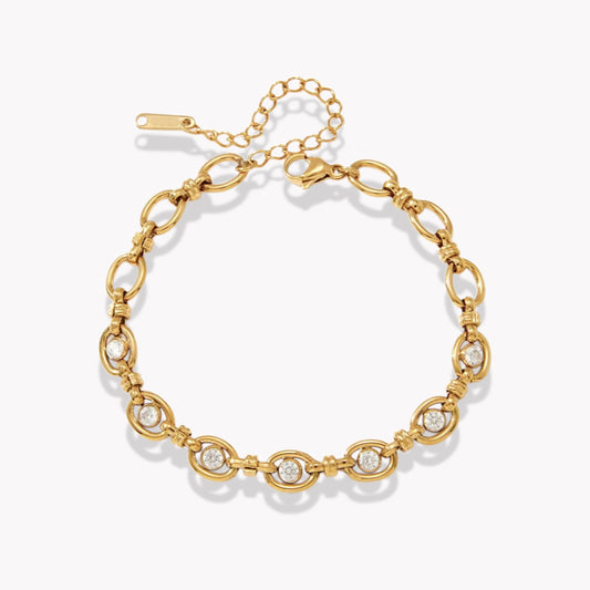 gold bracelet with genstones pictured on a light grey background