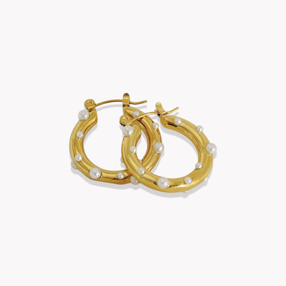 Gold hoop earrings with pearl accents on a white background