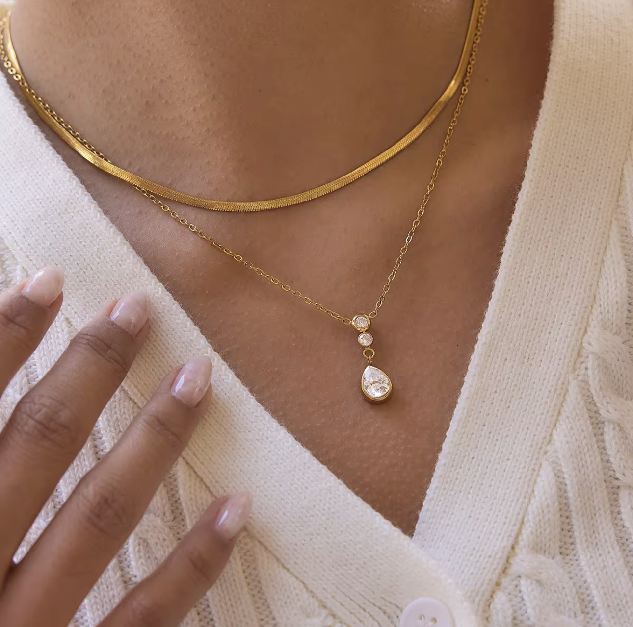 Double layer necklace featuring a top layer snake chain with bottom longer layer with pear shaped gemstone pendant pictured being worn