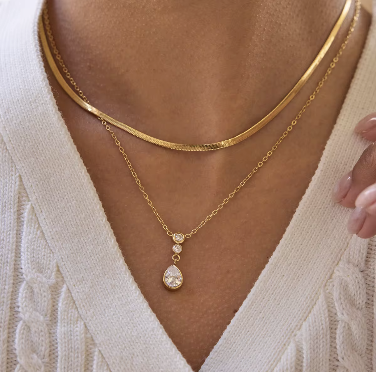 Double layer necklace featuring a top layer snake chain with bottom longer layer with pear shaped gemstone pendant pictured being worn