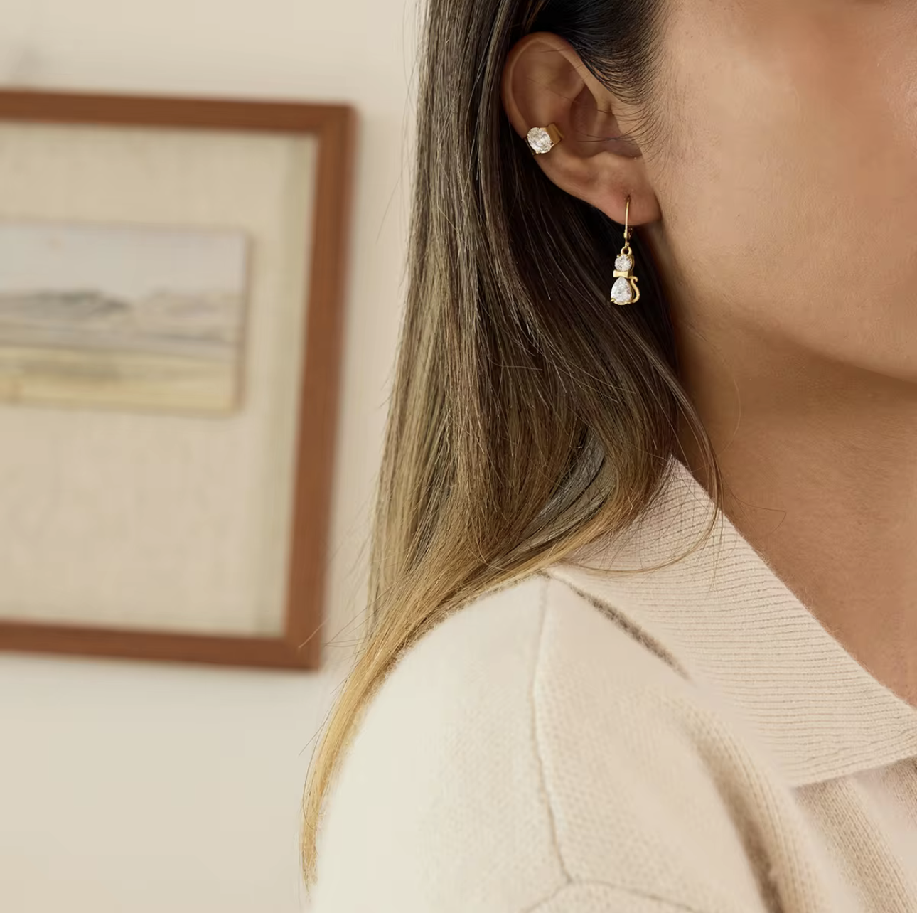 Close-up of a person wearing gemstone earrings with a blurred background