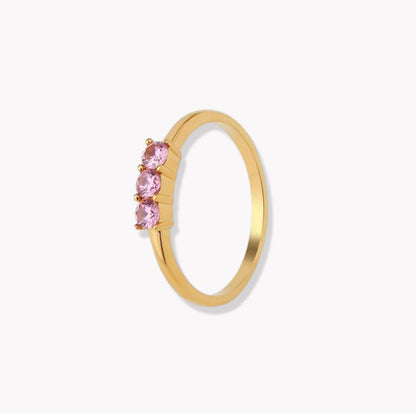 gold wing with pink gemstones on a light grey background