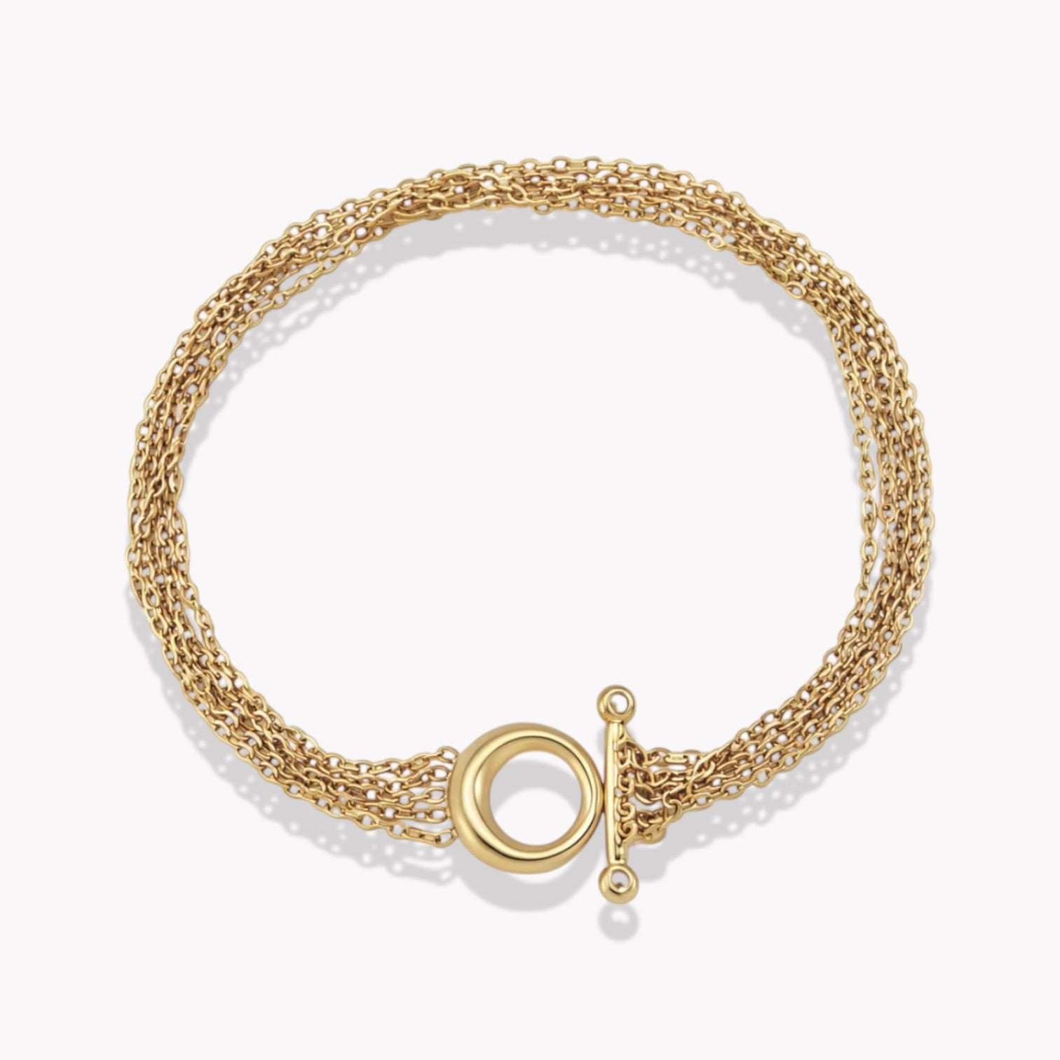 Gold bracelet with chain detail on a light coloured background