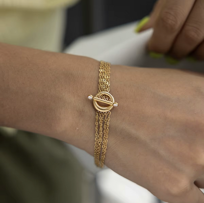 Close up of a gold bracelet being worn on a wrist