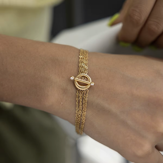 Close up of a gold bracelet being worn on a wrist