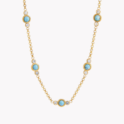 Gold necklace with turquoise gemstones on a white background