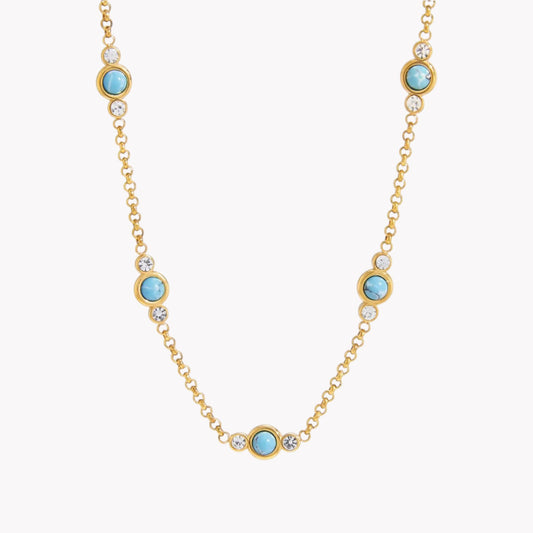 Gold necklace with turquoise gemstones on a white background