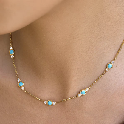 Gold necklace with turquoise stones on a person's neck