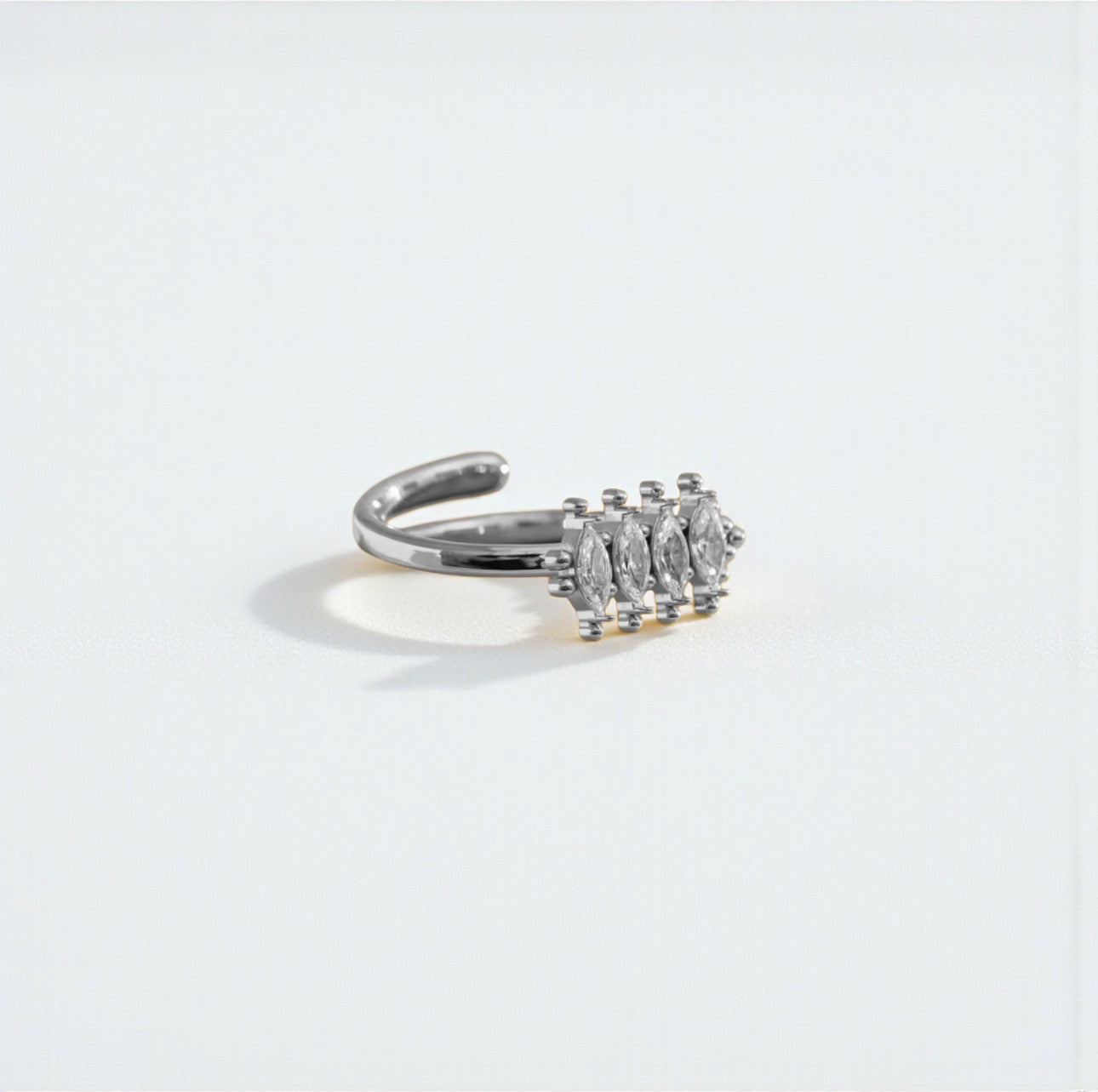 Silver ring with multiple diamonds on a light gray background